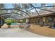 Beautiful backyard patio featuring a screened pool area, outdoor seating, and lush landscaping at 1509 Shadow Ridge Cir, Sarasota, FL 34240