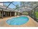 Beautiful pool with screened enclosure, surrounded by lush landscaping and patio area at 1509 Shadow Ridge Cir, Sarasota, FL 34240