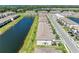 Community aerial view with townhomes lining a lake; lush landscaping and mature trees enhance the scene at 15164 Sunny Day Dr, Bradenton, FL 34211