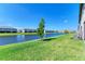 Beautiful backyard with green grass and a scenic view of the serene lake at 15164 Sunny Day Dr, Bradenton, FL 34211