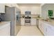 Modern kitchen with stainless steel appliances, granite countertops, and white cabinets at 15164 Sunny Day Dr, Bradenton, FL 34211