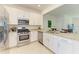 Modern kitchen featuring stainless steel appliances, granite countertops, and white cabinetry at 15164 Sunny Day Dr, Bradenton, FL 34211