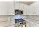 Modern kitchen with stainless steel appliances, granite countertops, white cabinets, and a gas range at 15225 Lyla Ter, Bradenton, FL 34211