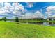 Scenic view of the pond and well-maintained green lawn and other residences on a sunny day at 15225 Lyla Ter, Bradenton, FL 34211