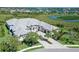 Stunning aerial view of a luxurious white home with a gray roof, surrounded by lush greenery and scenic waterways at 15315 Anchorage Pl, Lakewood Ranch, FL 34202