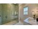 Stylish bathroom featuring glass enclosed shower with vertical tile, modern fixtures, and natural light at 15315 Anchorage Pl, Lakewood Ranch, FL 34202