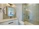 Contemporary bathroom with a glass enclosed shower and round mirror, showcasing modern fixtures at 15315 Anchorage Pl, Lakewood Ranch, FL 34202