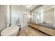 An elegant bathroom with soaking tub, double sinks, and a large framed mirror at 15315 Anchorage Pl, Lakewood Ranch, FL 34202