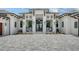 Close-up of a home's front entrance, with a beautiful front door and seating, set on a paver driveway at 15315 Anchorage Pl, Lakewood Ranch, FL 34202