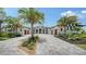 Beautiful home exterior with a large driveway, mature palm trees, and three-car garages on either side of the entryway at 15315 Anchorage Pl, Lakewood Ranch, FL 34202
