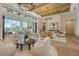 Open-concept living room boasts modern fireplace, comfortable seating, and scenic views of the outdoor pool at 15315 Anchorage Pl, Lakewood Ranch, FL 34202