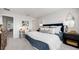 Comfortable bedroom featuring a bed with stylish pillows, a work desk, a modern mirror and tasteful décor at 16538 San Nicola Pl, Bradenton, FL 34211