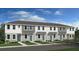Attractive townhome exterior with neat landscaping, light gray paint, gray shingles and light blue doors at 16538 San Nicola Pl, Bradenton, FL 34211