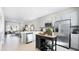 Modern kitchen featuring stainless steel appliances, white cabinets, an island, and open layout to the living area at 16538 San Nicola Pl, Bradenton, FL 34211