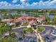 Aerial view displays the clubhouse, lake, parking, and pristine landscaping at 17110 Verona Pl, Bradenton, FL 34202