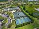 Aerial view showcases tennis and pickleball courts, surrounded by lush landscaping and parking at 17110 Verona Pl, Bradenton, FL 34202
