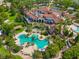 Aerial view of community clubhouse featuring a luxurious pool, covered patio, and lush greenery at 17110 Verona Pl, Bradenton, FL 34202