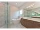 A bright bathroom featuring a glass shower, soaking tub, and a vanity with double sinks and modern finishes at 17110 Verona Pl, Bradenton, FL 34202