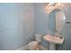 Powder room with modern fixtures, a stylish round mirror, and elegant pedestal sink at 17110 Verona Pl, Bradenton, FL 34202