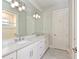 A spacious bathroom with double sinks, white cabinets, and modern lighting above the mirrors at 17110 Verona Pl, Bradenton, FL 34202