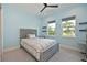 Cozy bedroom featuring a ceiling fan and natural light from two windows overlooking the landscaped yard at 17110 Verona Pl, Bradenton, FL 34202
