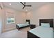 A cozy bedroom with two twin beds, neutral walls, and a window providing ample natural light at 17110 Verona Pl, Bradenton, FL 34202