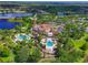 Aerial view of the clubhouse, multiple pools, and outdoor amenities overlooking a lake at 17110 Verona Pl, Bradenton, FL 34202