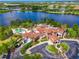 Aerial view of the clubhouse, pool, and outdoor amenities overlooking a lake at 17110 Verona Pl, Bradenton, FL 34202