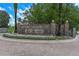 A stone entrance to the community of the Lake Club with mature landscaping and brick paved road at 17110 Verona Pl, Bradenton, FL 34202