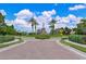 A landscaped entrance to a community with palm trees, manicured shrubbery, and stone monument at 17110 Verona Pl, Bradenton, FL 34202