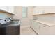 A well-equipped laundry room with white cabinets, modern washer and dryer, and a countertop with a sink at 17110 Verona Pl, Bradenton, FL 34202