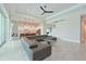 An open floor plan showcasing a large gray sectional couch, modern lighting, and a sleek kitchen with a breakfast bar at 17110 Verona Pl, Bradenton, FL 34202