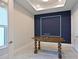 A modern home office with an accent wall, an ornate table, and a window providing natural light at 17110 Verona Pl, Bradenton, FL 34202