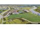 Wide aerial photo of the community amenities, featuring a pool, clubhouse, and large recreational field at 17209 Barnwood Pl, Bradenton, FL 34211