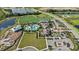 Aerial view of a community with a resort-style pool, clubhouse, playground and expansive green spaces and lakes at 17209 Barnwood Pl, Bradenton, FL 34211