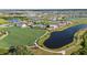 Community aerial view displaying amenities, including a pool, clubhouse, green spaces, walking paths, and a peaceful lake at 17209 Barnwood Pl, Bradenton, FL 34211