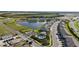 Aerial view of a community with new townhomes surrounding a beautiful pond and a community pool at 17209 Barnwood Pl, Bradenton, FL 34211