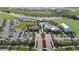 Aerial view showcasing the community center, pool area, ample parking, and surrounding lush landscaping and serene lake at 17209 Barnwood Pl, Bradenton, FL 34211