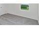 Bedroom with natural light, gray carpeting, and a window with green outdoor views at 17209 Barnwood Pl, Bradenton, FL 34211
