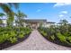 Charming clubhouse with a welcoming brick path surrounded by lush landscaping and palm trees at 17209 Barnwood Pl, Bradenton, FL 34211