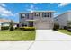 Two-story home featuring a manicured lawn, stone accents, and a neutral color palette on a sunny day at 17209 Barnwood Pl, Bradenton, FL 34211