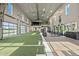 Well-equipped gym with turf, weight machines, natural light, and roll-up glass doors for an open-air feel at 17209 Barnwood Pl, Bradenton, FL 34211