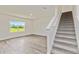 Bright room with staircase, wood flooring, and a large window showcasing scenic outdoor views at 17209 Barnwood Pl, Bradenton, FL 34211