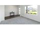 Bright living room with carpeted floor, a side table, a large window, and a modern door at 17209 Barnwood Pl, Bradenton, FL 34211