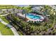 A beautiful pool area with lounge chairs, umbrellas, lush landscaping, and a covered seating area near the parking lot at 17209 Barnwood Pl, Bradenton, FL 34211