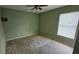 Spacious bedroom with carpet flooring, ceiling fan, and natural light from the window at 17215 Berwin Ave, Port Charlotte, FL 33948