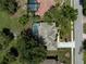 Aerial view of a home with a screened-in pool in the backyard surrounded by trees, with a driveway and a nearby road at 2016 White Feather Ln, Nokomis, FL 34275