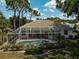Elevated rear view of a home featuring a screened-in pool and patio with manicured landscaping at 2016 White Feather Ln, Nokomis, FL 34275