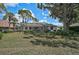 Backyard view showing well-maintained landscaping and manicured lawn with screened in pool and patio area at 2016 White Feather Ln, Nokomis, FL 34275