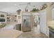 Spacious kitchen features a stainless steel refrigerator, stone countertops, and views into the dining room at 2016 White Feather Ln, Nokomis, FL 34275